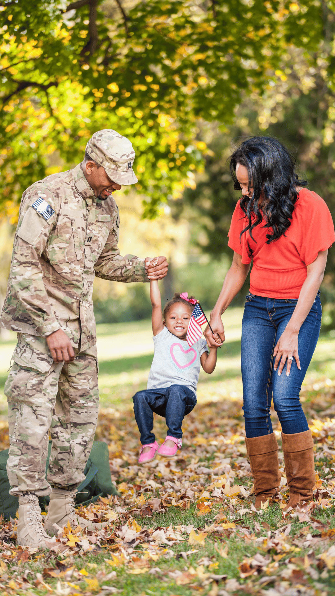 man in military uniform with woman and child outdoors